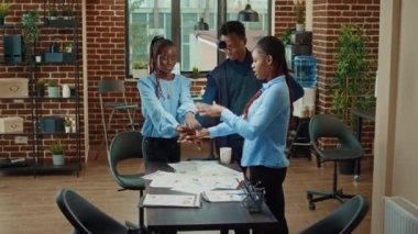 Gülümseyen iş arkadaşları başarının keyfini çıkarıyorlar, iş geliştirme ve artan kazanç elde ettikten sonra el ele tutuşuyorlar. Mutlu insanlar kurumsal istatistikler ve başarılı takım hakkında mutlu hissediyorlar..