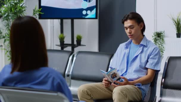 Hastane Lobisinde Oturan Genç Bir Yetişkin Resepsiyonda Doktorun Tıbbi Muayeneye — Stok video