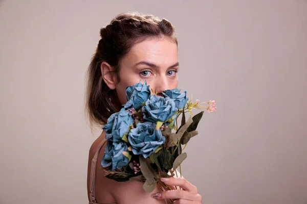 Mujer Joven Sosteniendo Ramo Rosas Azules Frente Cara Mirando Cámara —  Fotos de Stock