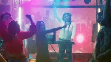 Gece kulübündeki dans partisinde eğlenen insanlar dans pistinde havalı hareketler sergilemek için modern dans savaşının tadını çıkarıyorlar. Dans eden ve müzik eşliğinde zıplayan mutlu yetişkinler..