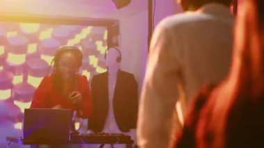 Çeşitli arkadaş grupları gece kulübünde modern funky müzik eşliğinde parti veriyor. Havalı insanlar dans pistinde toplanıp eğleniyorlar. Renkli ışıklar..