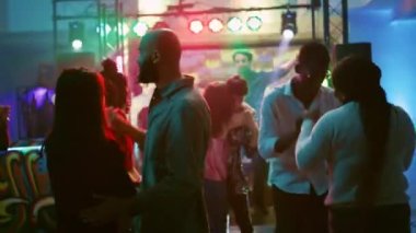 Mutlu insanlar slow müzik dansını seviyorlar, diskotekte parti yapıyorlar. Erkekler ve kadınlar çiftler halinde dans eder ve romantik anlarda eğlenirler, gece hayatı eğlencesi. El kamerasıyla..