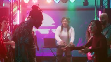 Klüpte eğlenen insanlar dans pistinde birden fazla kişiyle break dans savaşının tadını çıkarıyorlar. Arkadaşların havalı dans figürlerini ve diskotek danslarını gösteriyorlar. Üçayak atışı.