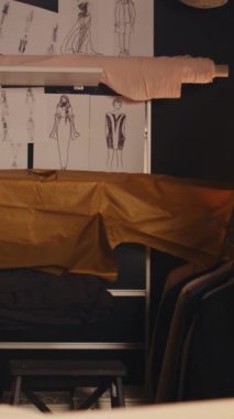 Moda ürünleri yaratmak için özel yapım kıyafetler için kullanılan dikey video lüks atölyesi. El işi konsepti için dikiş makineleri ve kumaşı olan terzi atölyesi, küçük işletme.