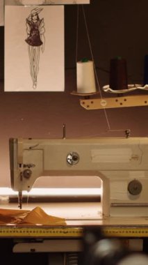 Dikey video terzi atölyesi dikiş makinesi ve özel yapım kıyafetler ve moda koleksiyonu için kullanılan aletler, üretim endüstrisi. Lüks atölyede endüstriyel terzilik ekipmanları. Kapat..