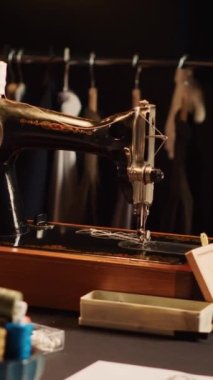 Atölyede dikey video eski moda dikiş makinesi, özel yapım giyim markası yapımında kullanılan terzilik aletleri. Profesyonel enstrümanları ve çalışma istasyonları olan tekstil endüstrisi