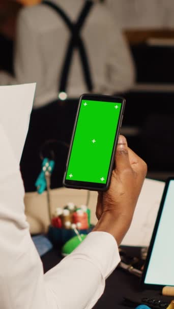 垂直视频调制解调器使用绿色屏幕的工作室与设计团队 查看智能手机上的孤立显示 在屏幕上使用空白色键模板的男性服装设计师 裁剪概念 — 图库视频影像