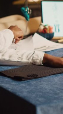 Dikey video terzisi masada kumaş hazırlıyor, uygun kumaşı ölçüyor, özel dikim elbiseler yapıyor. Couturier atölyedeki lüks müşteriler için yeni moda koleksiyonu tasarlıyor