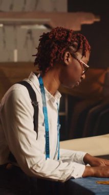 Dikey video tasarımcısı elbise ürünleri üzerinde çalışır, terzide lüks kıyafetler yaratmak için çizimlere bakar. Lüks atölye müşterileri için el yapımı ürünler yapan genç bir terzi..