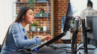 Profesyonel yazılımda oyun arayüzü oluşturmak için dokunmatik ekranı kullanan Asyalı kadın mühendis. Yapay zekayla çalışan yaratıcı geliştirici 3 boyutlu üretimi planlamak için.