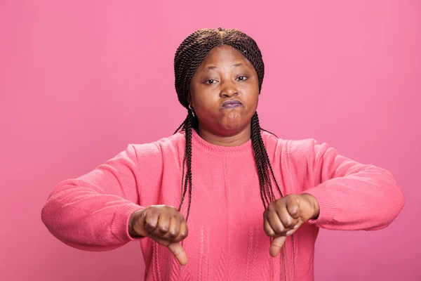失望的非洲裔美国人模型在工作室中展示了大拇指向下的象征 用双手做了消极的失败和不赞成的手势 表示不赞成和拒绝的女人 — 图库照片