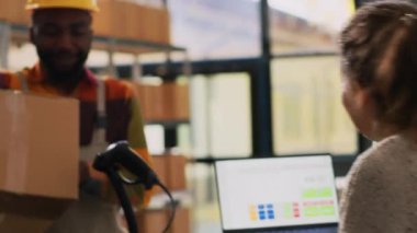 Depo çalışanı raflardaki paketlerdeki lojistiği kontrol ediyor, perakende mağazası siparişlerini onaylıyor. Kadın yemlik ve çalışan ürün kutularına bakıyor, kalite kontrol. El kamerasıyla..