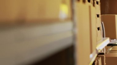 Depodaki telefona cevap veren erkek çalışanlar, ürün tedarik zinciri ve dağıtımı hakkında tartışıyorlar. Sipariş sevkiyatından önce malları denetleyen genç bir adam, kalite kontrol. El kamerasıyla..