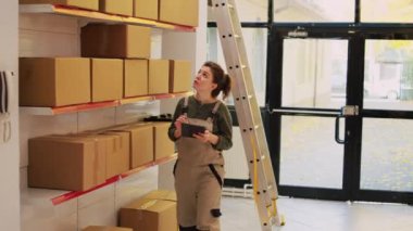 Depo müdürü, depolama odasındaki ürünleri denetlemek için sabit hattan konuşuyor. Genç yönetici, tablet kullanarak üretim ve kalite kontrolü hakkında karargahla görüşüyor.