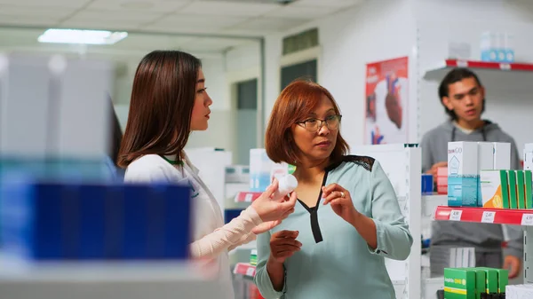 Trabajador Farmacéutico Mostrando Botella Píldoras Cardiología Cliente Asiático Farmacia Explicando — Foto de Stock