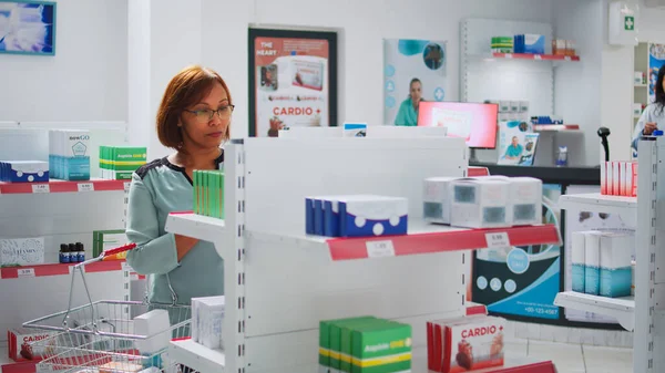 Asian Customer Putting Boxes Medication Drugstore Basket Looking Pills Package — Zdjęcie stockowe