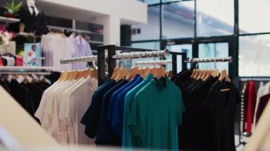 Boş modern butiğin renkli gömlekleriyle dolu rafların seçici odak noktası, resmi ve gündelik giyim tasarımı ile dolu. İndirimli kıyafetler, küçük ticari faaliyetler..