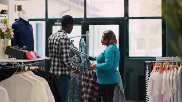 Afrykańska Para Kupuje Modne Ubrania Patrząc Regały Pełne Modnych Towarów — Wideo stockowe