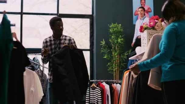 Neşeli Afrikalı Amerikalı Çift Kıyafetlerle Oynuyor Modern Butikte Şakacı Davranıyorlar — Stok video