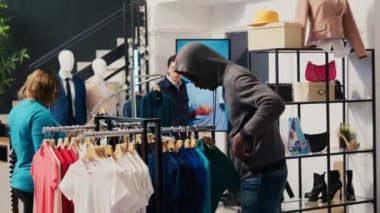 Mağaza hırsızı Asyalı güvenlik görevlisi tarafından yakalanarak alışveriş merkezinden moda malları çalmaya çalışıyor. Afrika kökenli Amerikalı çift, vücutguradla tartışıyor ve giyim mağazasında suçlamalardan kaçmaya çalışıyor.