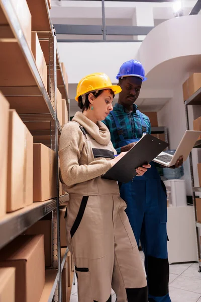 Warehouse Assistants Reading Inventory Report Comparing Data Laptop Clipboard Storehouse — Stock Photo, Image