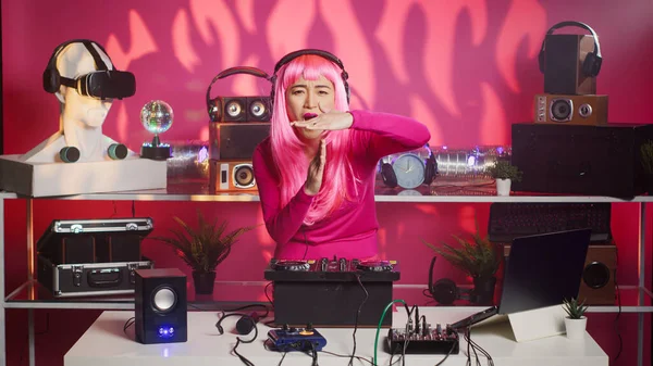拥有粉红头发的亚洲艺术家使用Dj混音器的控制台 与歌迷一起唱歌 晚上在俱乐部里玩得很开心 音乐家用专业音响设备表演 — 图库照片