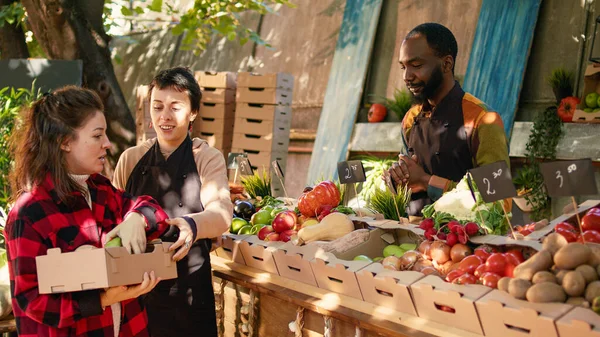 资深客户希望从非洲裔美国卖家那里购买有机产品 谈论健康的营养和当地产品 老人在市场摊位上买水果和蔬菜 — 图库照片