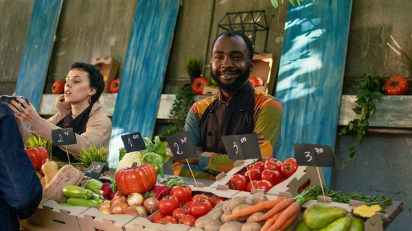 在农贸市场工作的形象男性农民站在那里销售生态有机水果和蔬菜 作为摊贩和展示新鲜天然土生土长的产品的年轻人 — 图库照片
