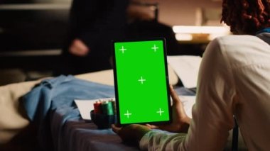 Tablette yeşil ekran kullanan tasarımcı atölyedeki modern krom anahtar görüntüsüne bakıyor. Özel yapım terzilik, ekranda izole edilmiş maketi olan Couturier holding cihazı. Kapat..