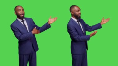 Afrikalı Amerikalı işçiler stüdyoda reklam yapıyor, yeşil ekran arka planına işaret ediyorlar. Erkek şirket müdürü sol ya da sağ tarafta reklam gösteriyor, işadamı yana bakıyor..