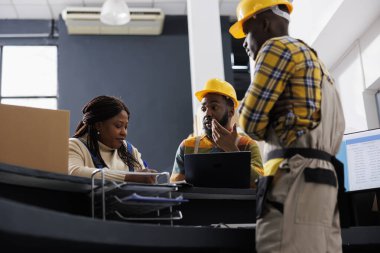 Postane çalışanları sipment şirketinin deposunda paket alımını yönetiyor. Afro-Amerikan teslimat ekibi resepsiyondaki fabrika nakliye işlemini denetliyor.