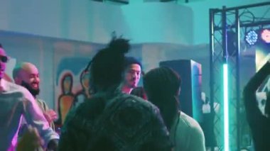 Bir sürü insan müziğe atlıyor, gece kulübünde dans pistinde mutlu hissediyorlar. Genç funky arkadaşlar sahnede DJ 'le elektronik müzik eşliğinde dans ediyor, spot ışıklarıyla parti yapıyorlar..