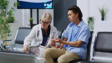 Glukometre enstrümanını kullanarak glikoz seviyesini ölçen yaşlı doktor, hastane bekleme odasındaki check-up randevusu sırasında diyabetik hastayla sağlık muayenesi yapıyor. Tıp konsepti