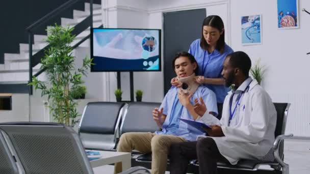 Medisch Personeel Helpt Gewonde Patiënt Halsband Doen Terwijl Hij Probeert — Stockvideo