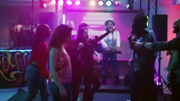 男人和女人用电子音乐在时髦的派对上跳舞 在社交聚会上与清凉的舞蹈大战嬉戏 年轻的朋友在俱乐部的舞池里聚会 炫耀一番 手持射击 — 图库视频影像