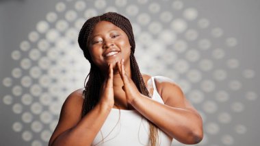 Beauty model applying face cream to create skincare ad, using moisturizer or serum to nourish glowing skin with imperfections. Young woman being gentle with creams on cheeks, natural girl.