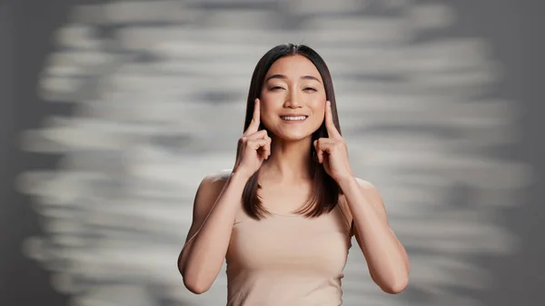 Beautiful girl using moisturizer on bare luminous skin, creating skincare ad campaign for products. Sensual gentle person promoting beauty routine cosmetics, apply face cream on camera.