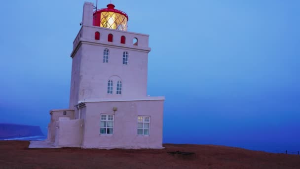 在北极海岸线上的Dyrholaey灯塔 美丽的老建筑 岸上有航标灯 塔体结构用于指导冰岛岩悬崖 即城市景观 手持射击 — 图库视频影像