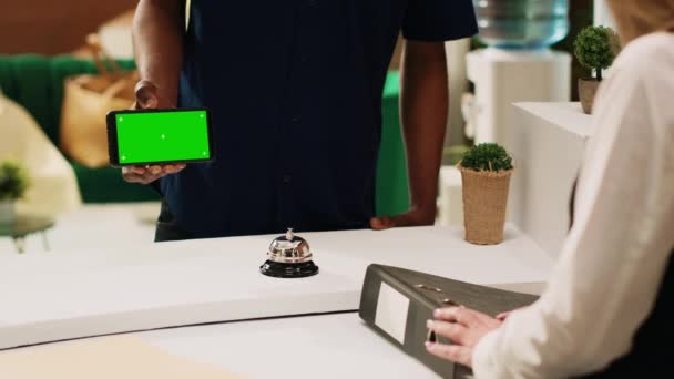 Konuk Yeşil Ekranlı Bir Telefon Gösteriyor Elinde Lobideki Otel Personeline — Stok video