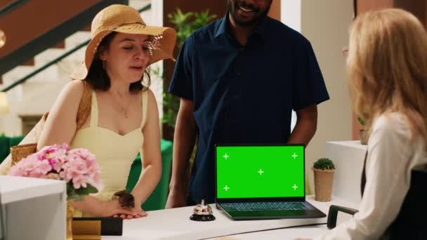 Receptionist Welcoming Tourists Using Greenscreen Display Laptop Talking Couple Check — Stock Video