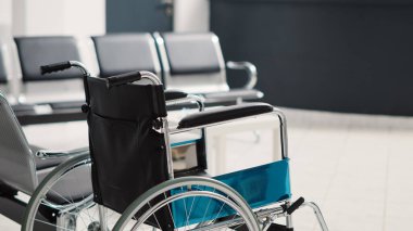 Tekerlekli sandalye, sağlık sigortası ve engelli dostu kliniğinde fiziksel tedavi için kullanılan boş bekleme odasında. Oturma yerleri ve tıbbi formlarla kayıt için resepsiyon..