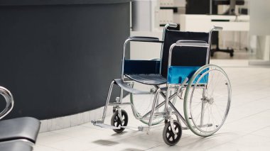 Tekerlekli sandalye hastane lobisine yerleştirilmiş. Hastane resepsiyonu, teşhis merkezinde tıbbi randevular için kullanılıyor. Maluliyet dostu klinikte tedavi, danışma masası..