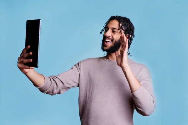 在数字平板电脑上的视频通话中 用在线会议软件应用微笑Arab男子挥手致意 愉快的人在视频会议上进行虚拟交流的同时问候朋友 — 图库照片