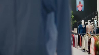 Boş giyim mağazası moda mağazasında asılı günlük ve resmi giyim eşyaları ile dolu. Raflar ve askılar, indirimli moda kıyafetler ve aksesuarlarla dolu, küçük ticari faaliyet..