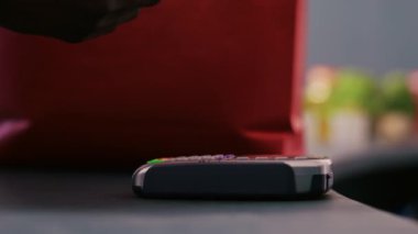 Modern butikte şık ürünler ve aksesuarlar aldıktan sonra Afro-amerikan müşterileri telefon faturalarını kullanıyor. Tezgahta günlük kıyafetlerin parasını ödeyen kişi. Kapat..