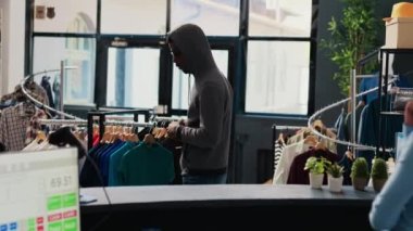 Asyalı koruma tarafından yakalanan soyguncu giyim mağazasından moda ürünleri çalmaya çalıştı. Afro-Amerikalı hırsız, güvenlik görevlisiyle tartışıyor ve suçtan kaçmaya çalışıyor.
