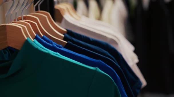 有选择的焦点衣架充满了五颜六色的衬衫 空空如也的现代精品与时髦的衣服 在购物中心配备有休闲和正式服装的服装店 时尚概念 — 图库视频影像