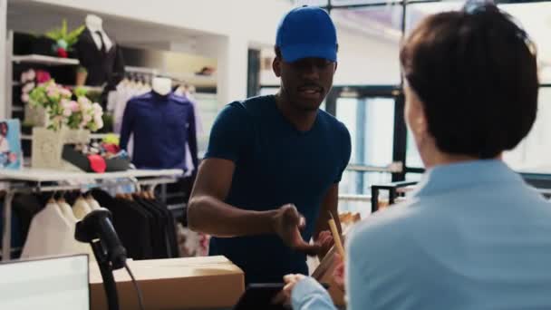 非裔美国人快递员在现代精品店签署包装报告 与工人讨论销售细节 处理网上订单 准备送货包的女经理 — 图库视频影像
