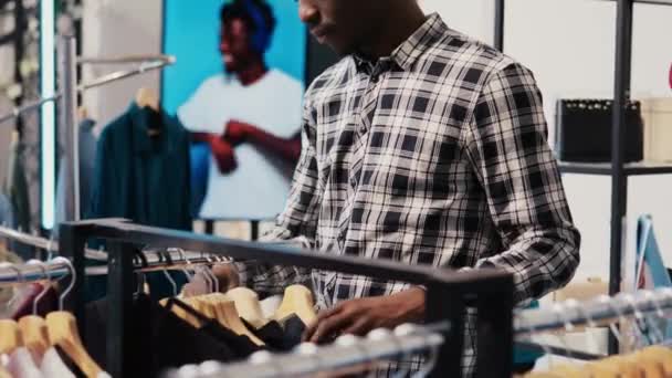 African American Man Shopper Tittar Modekollektion Analysera Merchandise Tyg Modern — Stockvideo