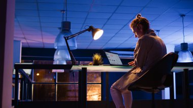 Geceleri mali raporlar üzerinde çalışan kadın çalışanlar, kar büyümesini planlamak için başlangıç masasında oturuyorlar. Genç girişimci ekonomi grafikleri verilerini kontrol ediyor. El kamerasıyla..